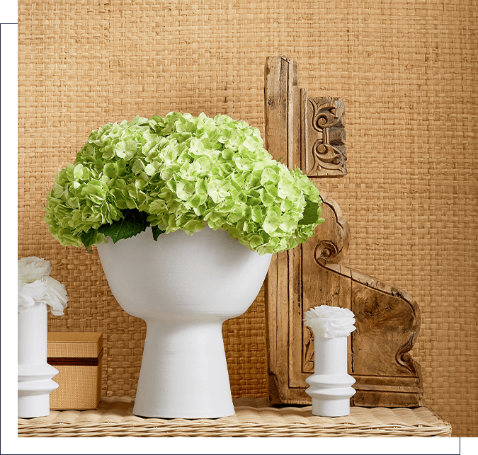 A white toilet with green flowers in it.