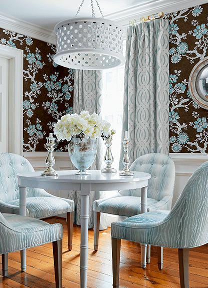 A dining room with blue chairs and white table.